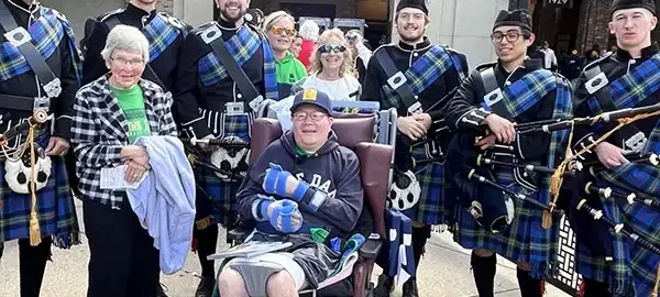 An elderly couple having their wish granted with bagpipe players