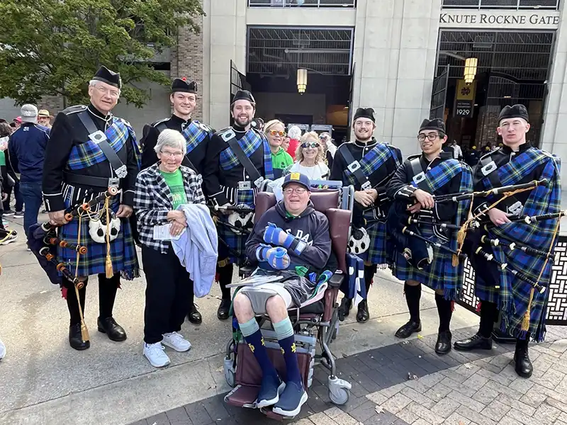Elderly couple with bagpipe players